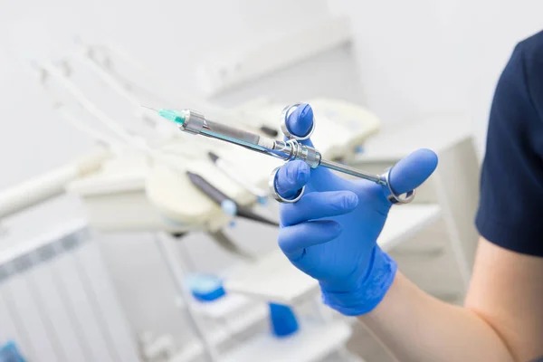 Hand of dentist holding dental syringe to make a Dental injection — Stock Photo, Image