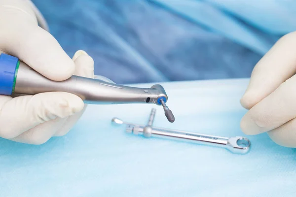 Крупним планом зубний імплантат в руках стоматолога. Проводиться операція з імплантації . — стокове фото