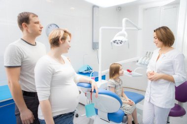 Bir kadın diş hekimi bir diş kliniğinde bir çocuk ve ailesi ile iletişim kurar. Kızın annesi hamile.