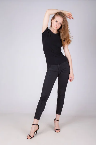 Vékony, fiatal nő fekete ruhát a világos háttér — Stock Fotó