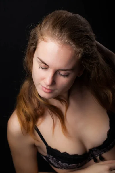 一个年轻，运动和性感的女人在黑色背景的黑色内衣的肖像 — 图库照片