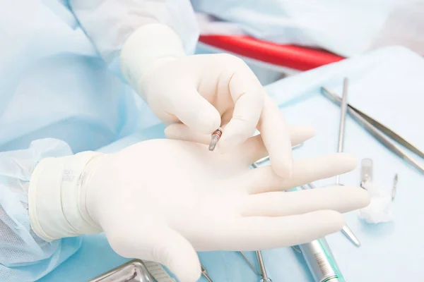 Médico dentista detém implante dentário — Fotografia de Stock