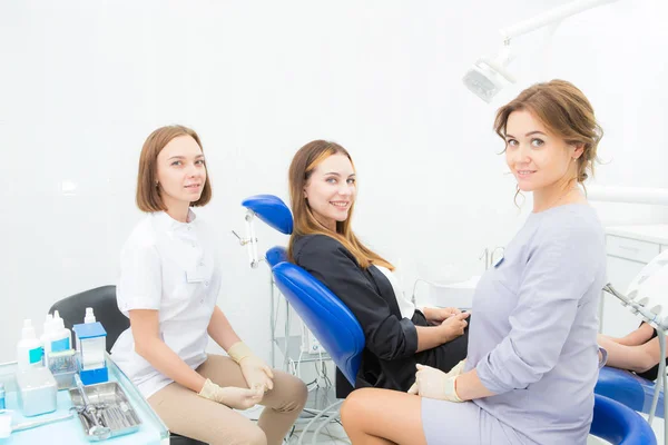 Две женщины-стоматолога и пациент в процедурной — стоковое фото