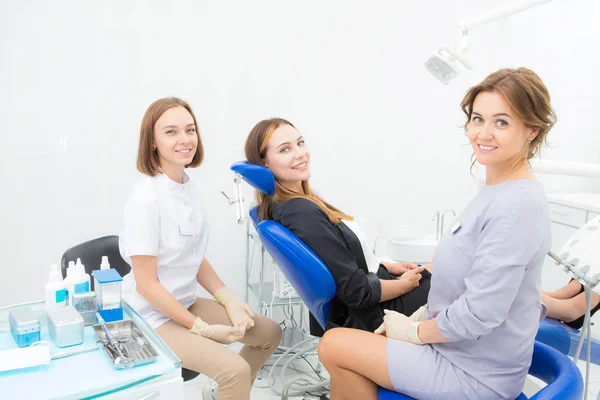 Две женщины-стоматолога и пациент в процедурной — стоковое фото
