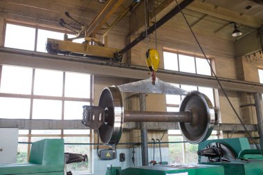 onarım sırasında demiryolu tekerleği tamir atölyesinde bir vinç tarafından kaldırıldı