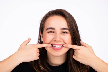 Güzel bir kadın ağzının kenarlarını geriyor ve gülümsüyor.