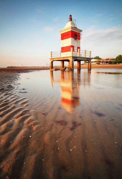 红色灯塔在日出在利尼亚诺萨比亚多罗海滩，弗里利 — 图库照片