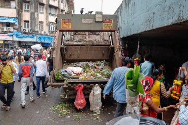 Mumbai, Hindistan, 10-10-2019: Mumbai 'deki Dadar çiçek pazarından çöp toplayan bir çöp toplama aracı