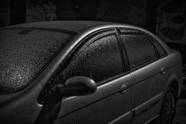 Car on the street covered by icy rain  in black and white — Stock Photo, Image