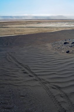 Bisiklet tekerlekleri siyah lav kum üzerinde iz