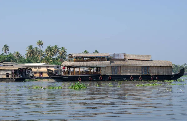 ALAPPUZHA, KERELA, INDIA - 22 Ocak 2020 - Güzel kayıkhane turistleri parlak güneş altında göle taşıdı