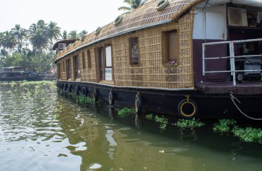 ALAPPUZHA, KERELA, İNDİYA - 22 HAZİRAN 2020 - Güzel kayıkhane parlayan güneş altında göl kenarına park etmiş