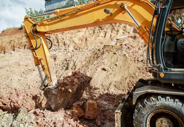 Excavator digging a hole. Work on the construction site