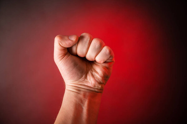 Fist on red background. Concept threat