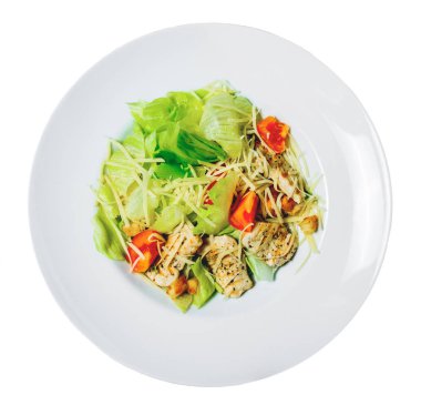 Romaine marul, domates, ızgara tavuk, kruton ve peynir ile Sezar salatası bir tabakta. Beyaz arka planda yalıtılmış.