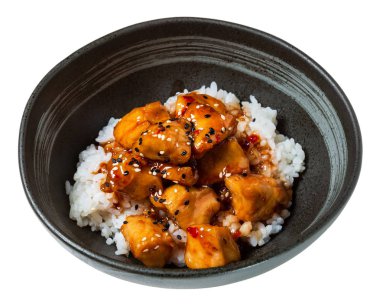 Kızarmış tavuk, sosu, pirinç ve susam siyah kase lezzetli yemek. Beyaz arka plan üzerinde izole.