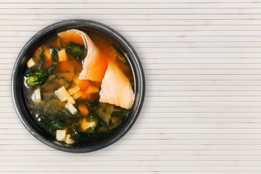İştah açıcı çorbası ile somon, tofu ve deniz yosunu. Ahşap arka plan kopya alanı ile. Asya mutfağı.