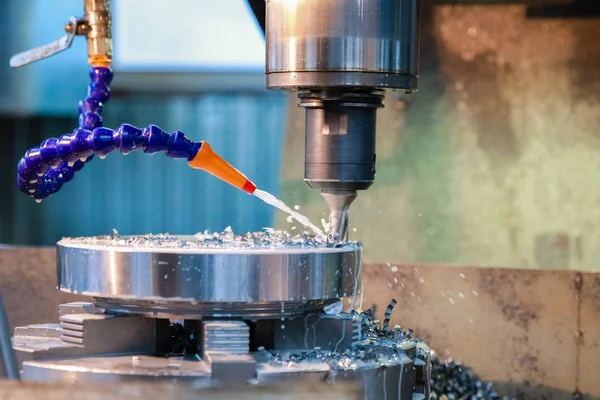 Delme makinesi bir delik metal ürün yapar. Soğutucu üzerinde matkap yağıyor.