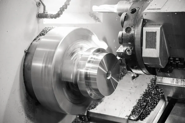 CNC lathe processes metal part. Automated production.