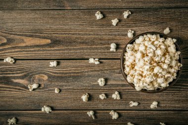 Eski bir ahşap masa üzerinde bir kase patlamış mısır. Kopya alanı.