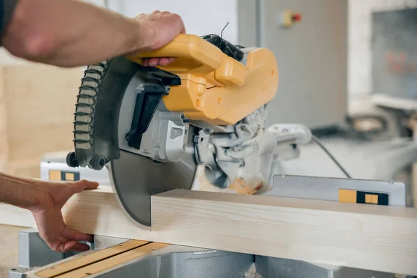 Worker cuts a wooden beam circular saw. — Stock Photo, Image