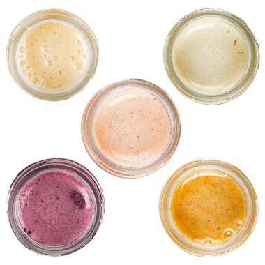 Cam kavanozlarda farklı tipte bal. Beyaz bir arka planda izole edilmiş. Yukarıdan görüntüle.