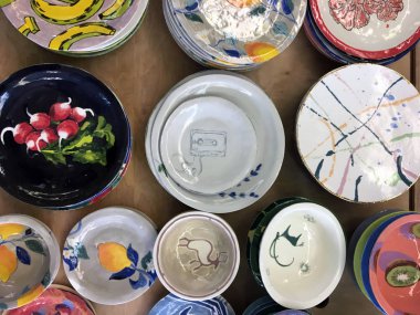 Resimlerle el yapımı seramik tabaklar. Basit rustik el yapımı beyaz tabak. Dükkanda el yapımı Seramik Tabaklar. Seramik plakalar üzerinde kuşların suluboya çizimleri. Muz resimleri