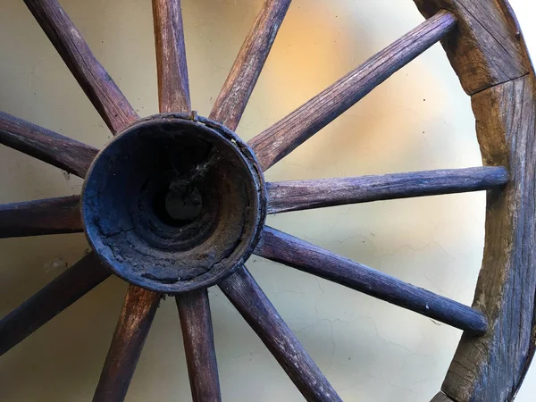 Ahşap araç tekerleği arka plan açık-kahverengi renk karşı, yatay bir yakın. Çatlak ahşap wain tekerleği. Kırsal bir mahkemede vintage ahşap tekerlek. Ahşap tekne/gemi direksiyon askı