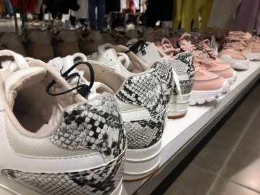 Ayakkabı ayakkabı saklamak satmak için ekran için sokak modası giyen rafta Sneaker ayakkabı. Toplu pazar dükkanı. Moda Casual Kadın Sneakers Yakın Görünümü. Yılan baskılı spor ayakkabılar. Modern kadın ayakkabısatışı