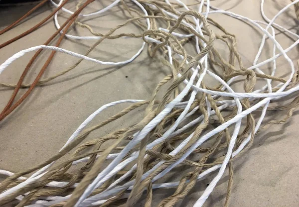 Paper Yarn. Pile of tangled gray and white yarn with a single end leading out. multicolored yarn closeup