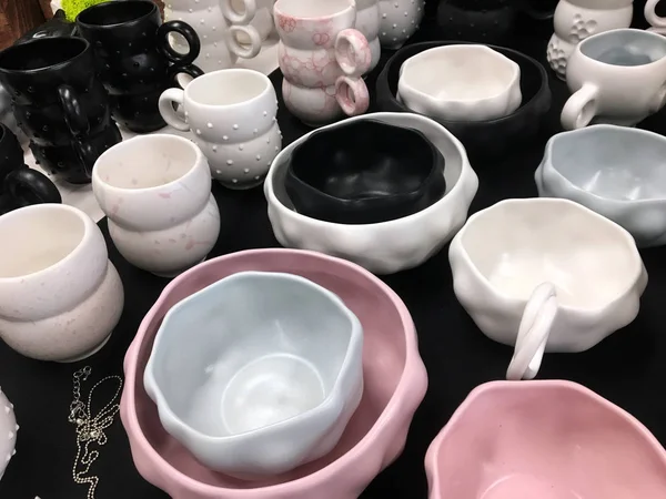 Designer ceramic cup background. Handmade ceramic cup. Collection of vintage ceramic cups on display. Collection of dishes for the kitchen selling in the store. Modern handmade ceramic tableware.