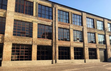Sokaktaki eski fabrika. Büyük pencerelerile büyük tuğla bina. Mimarinin detayları. Eski fabrika. Loft tarzında ofis binası. Büyük Pencereler. Kırmızı tuğla duvar