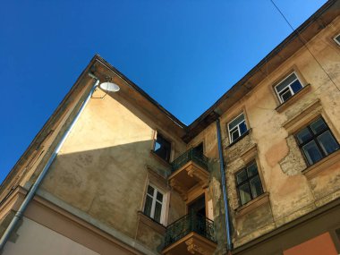 Sokak Lviv Eski Shabby Evi. Eski sarı evin köşesi. Eski Bir Hastalık Evi'nin Köşesi'nin yakın çekimi. Pencereleri ve balkonları ile çok katlı bir evin sarı eskiz li cephesi