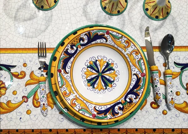 Ethnic ceramic tableware. Decorative ceramic glasses and plates with traditional ornament. Table setting. Provencal style tableware