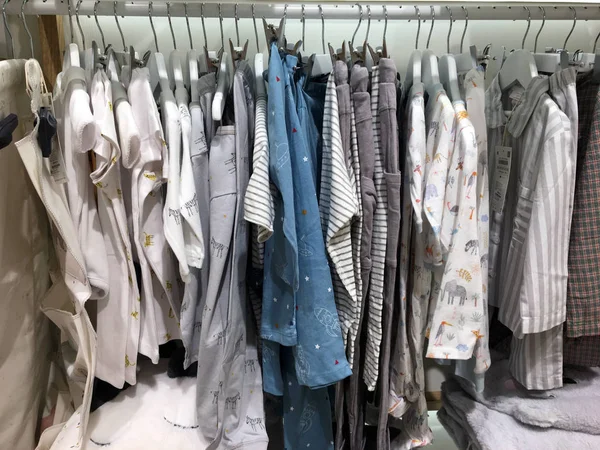 Children\'s clothes on hangers in a store. Fashionable clothes for children. Rack of children\'s clothing displayed in a shop. Clothing Fashion Shop. Close-up of hangers fashionable clothes.
