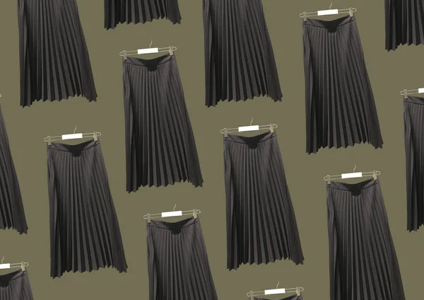 Black pleated long skirt isolated on green background pattern. Women\'s Elastic Waist Band Pleated Retro Maxi Long Skirt Dress. Long Accordion Pleated Skirt. Composition of clothes. Flat lay, top view