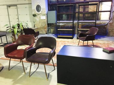 Eski rahat deri koltuklar. Antika bronz deri koltuklar. Beton zemin ve tasarım aksesuarlarıyla modern çatı katı oturma odası. Stüdyo daire