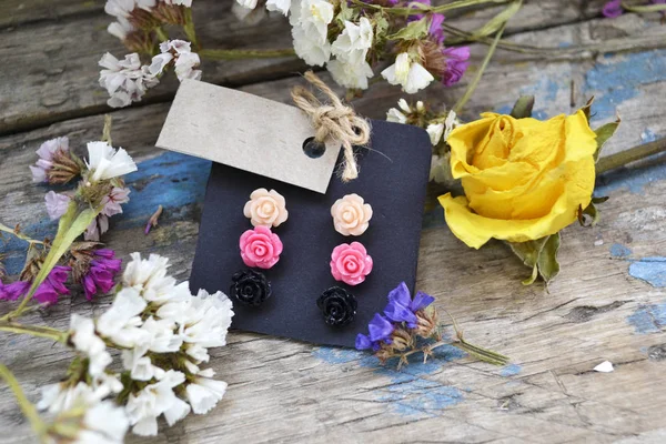 Small plastic rose earrings. A set of small earrings with a price tag. Dried Flower Decor. Women\'s Jewelry Store