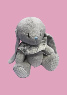 Pembe arka planda izole edilmiş gri sevimli oyuncak tavşan. Peluş tavşan deseni. Çocuk konsepti. Oyuncakların bileşimi. Düz yerde, üst tarafta. Boşluğu kopyala