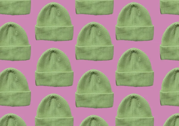 Green winter hipster hat pattern isolated on pink background. Fashion casual winter hat. Winter Wooly Hat. Winter clothes pattern. Banner concept