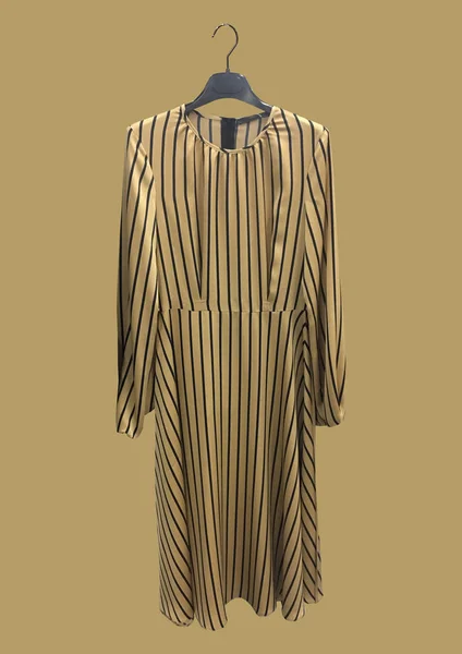 Beautiful elegant beige striped dress on a hanger isolated on brown background. Long silk dress with long sleeves. Composition of clothes. Flat lay, top view, copy space. Clothes pattern