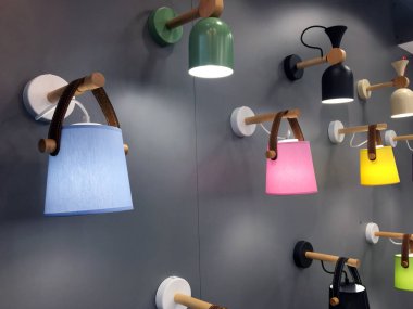 Gri duvardaki çok renkli küçük abajur duvar ışıkları. İskandinav tarzı ahşap lamba. Bir çok ışığın görüntüsü. Işık Mağazası. Deri kayışlı orijinal gece lambası. Birçok ışığın görüntüsü