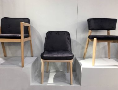 Mobilya mağazasında yumuşak döşemeleri olan şık ahşap tasarımcı sandalyeleri. Oturma odası için yemek sandalyeleri. Şık ahşap sandalye. Rahat Oturan Modern Kumaş Döşeme Tahta Salon Sandalyesi