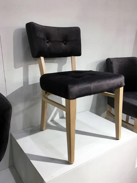 Stylish wooden designer chairs with soft upholstery in a furniture store. Dining Chairs for Living Room. Stylish Wood Chair. Comfortable Sitting Modern Fabric Upholstered Wooden Lounge Chair