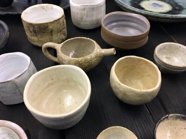 Karanlık ahşap üzerine modern çömlek. Dekoratif seramik tabak. El yapımı koyu çömlek. Seramik kil boş el yapımı kaseler ve koyu arkaplanda bardak. Çömlek, toprak, mutfak gereçleri..