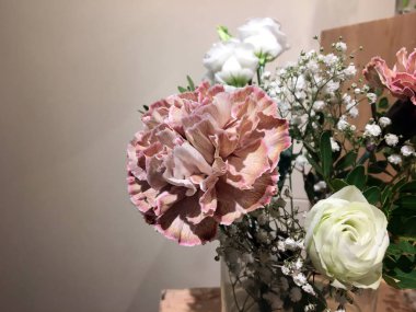 Küçük cam vazo, bir buket gül ve ahşap kutuda kurutulmuş çiçekler. Düğün dekoru. Gül ve yeşil dallı küçük cam vazo. İçi çiçeklerle dolu.