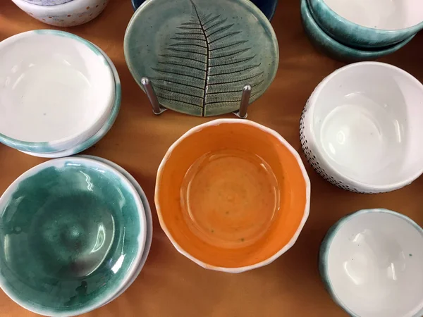 Wielokolorowe Ceramiczne Miski Pomarańczowym Tle Zielona Płyta Ceramiczna Imprint Sklep — Zdjęcie stockowe