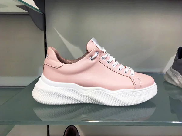 Ayakkabı mağazasındaki raflarda parlak renkli aksanlı beyaz platform ayakkabılar. Kitle marketi. Moda Gündelik Kadın Spor Ayakkabıları 'nın yakın görüntüsü. Kadınlar için Yüksek Platform Spor Ayakkabıları. Moda Spor Ayakkabıları