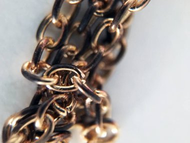 Beyaz arka planda klasik altın zincir yakın plan parçası. Tek zincirli halkaların birliği, birlik kavramı. Ev içi kullanım için ekipman. Mücevher üretimi. Zincirli kolye