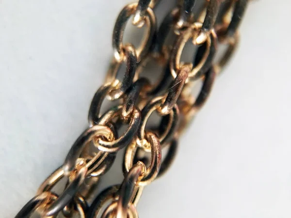 Vintage gold chain closeup fragment on white background. Unity of rings of one chain, concept of unity. Equipment for domestic use. Manufacture of jewelry. Chain necklace